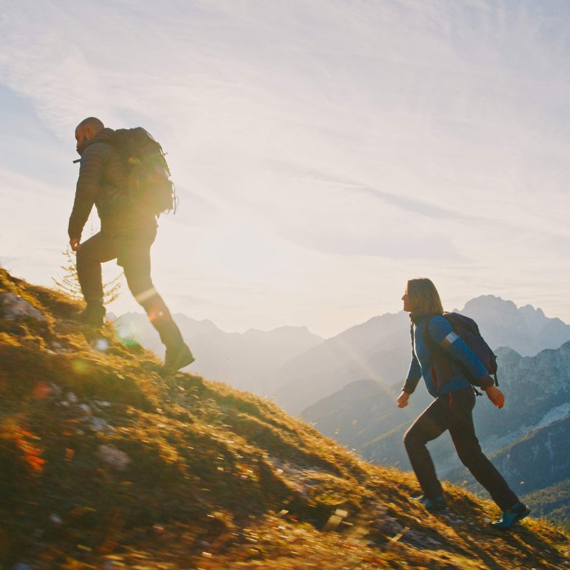 A man and woman hiking a mountain