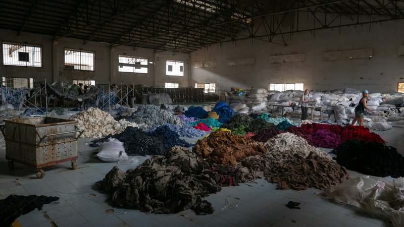 A warehouse with a pile of mass-produced textiles (Photographer: Francois Le Nguyen)
