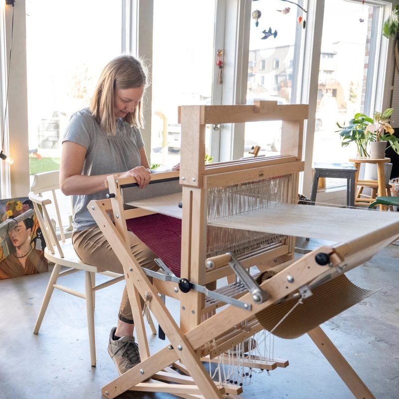 Weaving on a Schacht Wolf Pup LT floor loom (Source: Schacht Spindle Company)