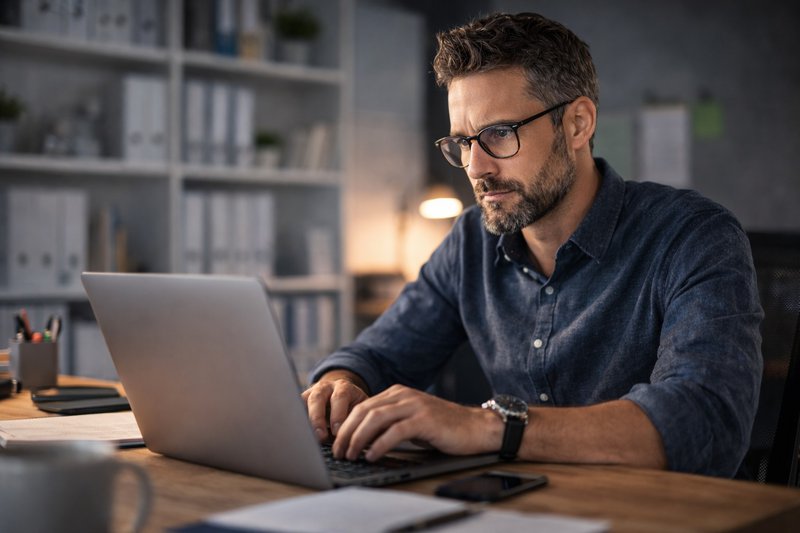 Accountant werkt geconcentreerd aan boekhoudsoftware op laptop voor het automatiseren van meerdere klantadministraties