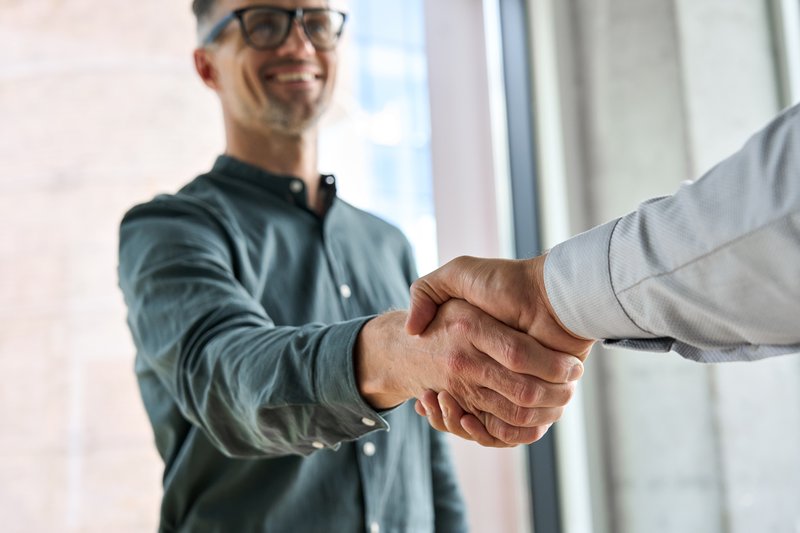 men shakes hands after a successful door-to-door sales meeting