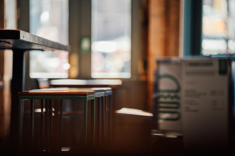 Bar stools and a box in a dimly lit room. Borrowers turn to SBA franchise financing for their QSR.