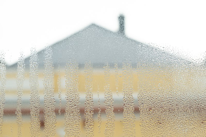 Wet window glass surface with heavy moisture and misted texture