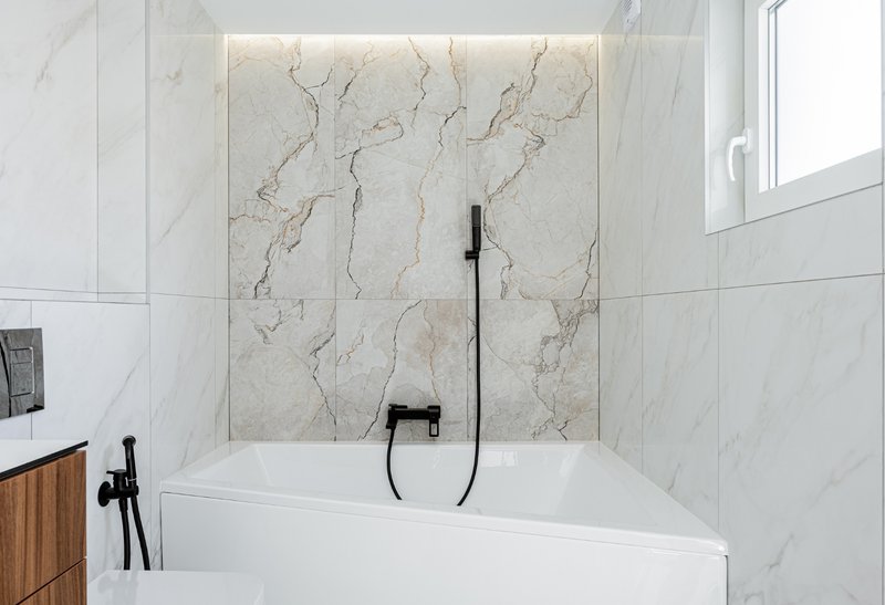 Reducing the number of seams and joints is one of the most effective ways to lower risk in tub-to-wall transitions.