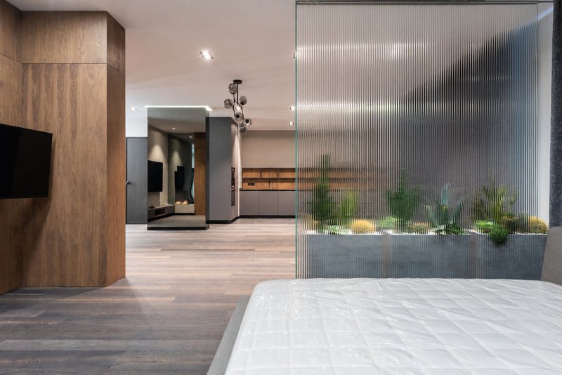 Reeded glass wall panels inside bedroom.