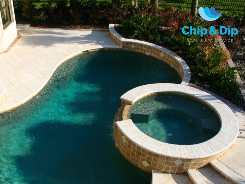 A fiberglass above-ground pool in a spa setup, cascading into a larger traditional pool.
