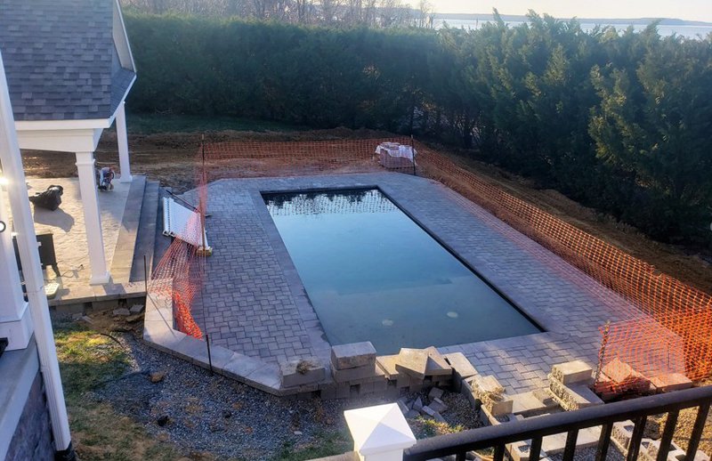 a classic rectangular fiberglass inground pool by the lake