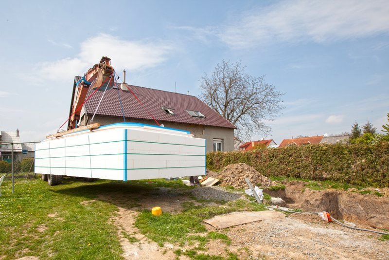 a fiberglass pool being hoisted to the site