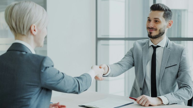 a woman shaking hands. referral marketing for financial advisors