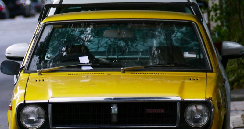 a yellow car parked on the side of the road