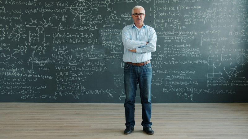 Man stands in front of chalkboard with complex equations