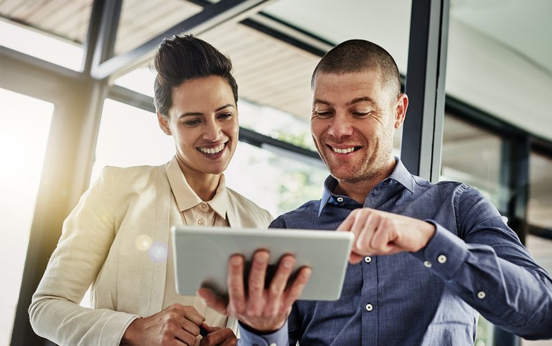 Employees looking at tablet, reviewing revenue share model for associations