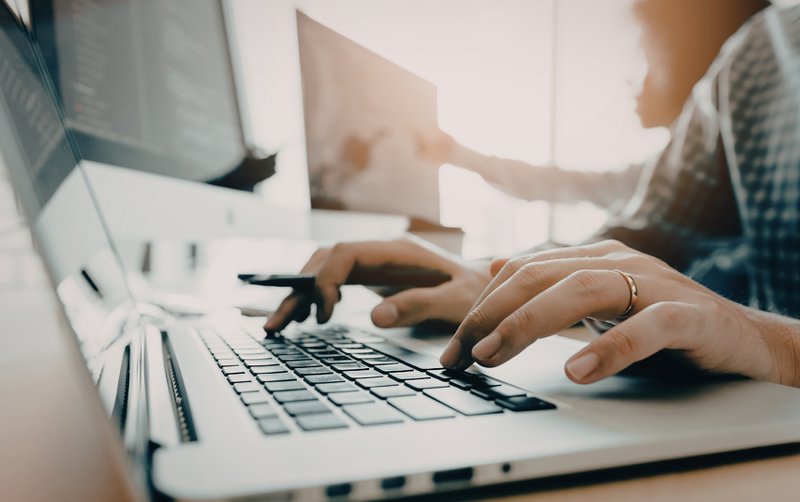 Woman writing articles from AI-generated B2B blog topics.
