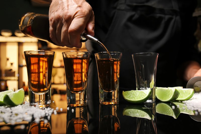 Man pouring RTD cocktails into shot glasses