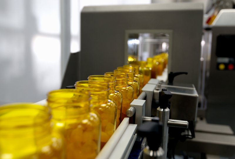 Capsules in bottles in a conveyor belt from a supplement manufacturer.