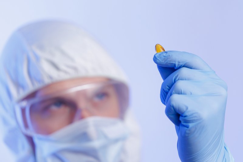 Pharmaceutical manufacturer inspecting supplement dosage.