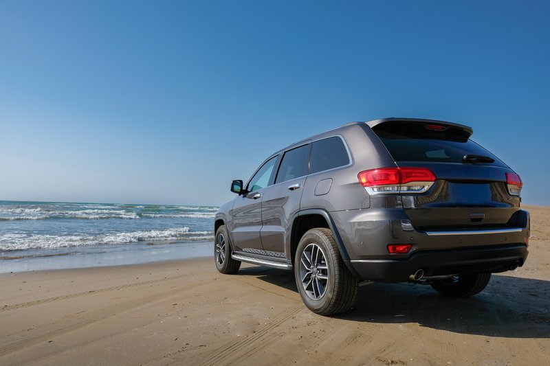 An SUV driving on sand.