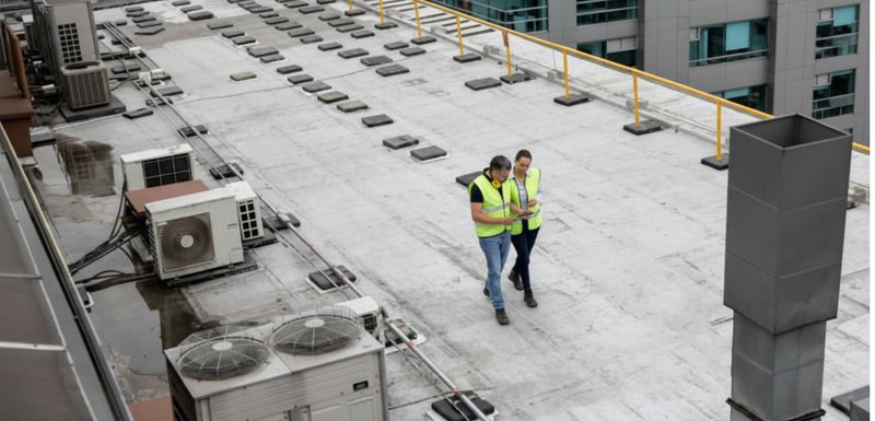 a pair of workers inspecting the roof. roof leaks