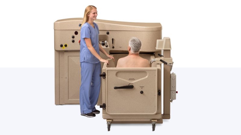 Caregiver assisting a resident using modern bathing equipment to improve staff efficiency and reduce assisted living facility costs