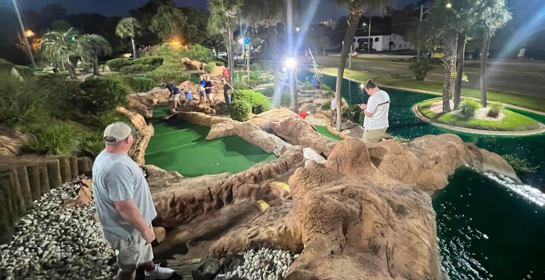 Mini golf signup players competing under the lights Mini golf signup players competing under the lights