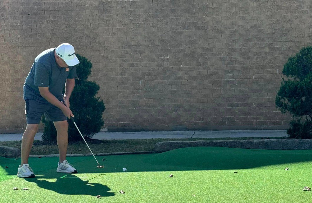 Mini golf player lining up a putt during local leagues competition. Mini golf player lining up a putt during local leagues competition.