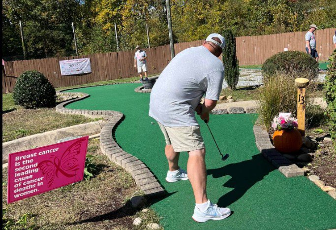 Mini golf player competing on an outdoor course during local leagues event. Mini golf player competing on an outdoor course during local leagues event.