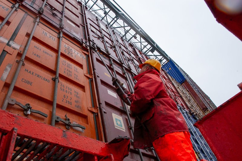 Worker securing cargo containers