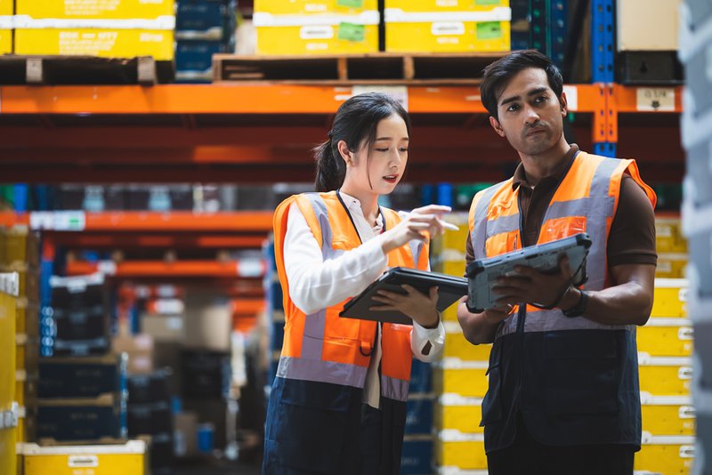 Warehouse employees using predictive analytics to track shipment