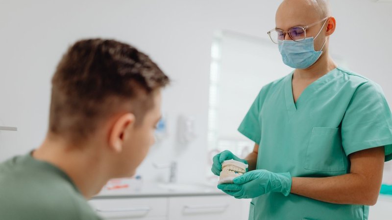 Dentist reviewing dental malpractice insurance coverage with patient in clinic