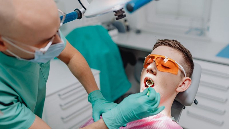 Dentist reviewing patient records to reduce dental malpractice insurance risk