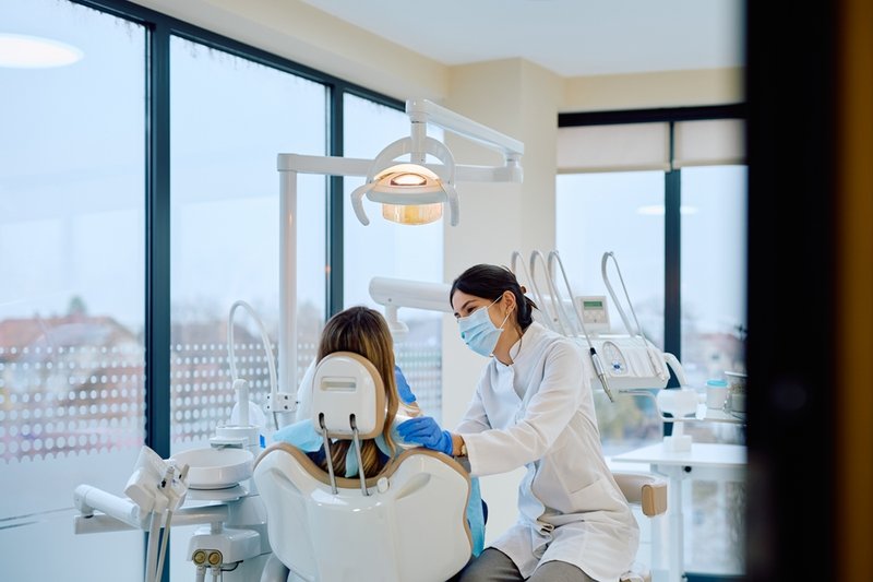 A dentist consults with a patient inside a modern dental clinic during a routine appointment.