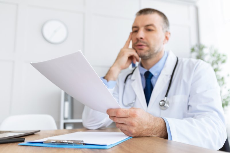 A medical professional reviewing a document.