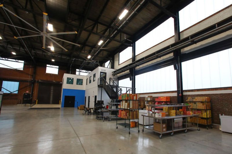 A spacious warehouse interior featuring high ceilings and rows of protective Warehouse Windows.
