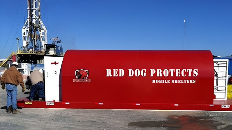 Crew members standing near a protective unit used as Oil Rig Storm Shelters.