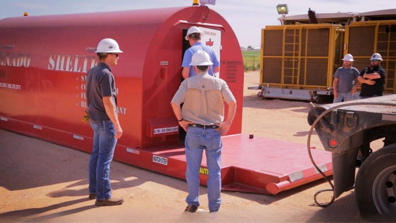 Professionals evaluating a heavy-duty unit on-site with a storm shelter manufacturer.