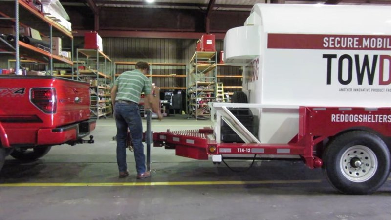 Hitching a safety unit inside a warehouse to transport portable storm shelters.