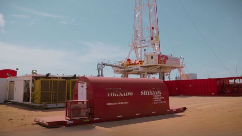 Modular buildings and a red dog shelter parked near an oil rig, representing Modular Infrastructure Solutions.