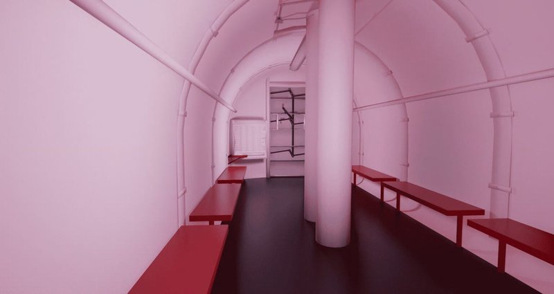 The interior of a Red Dog industrial storm shelter, featuring a reinforced cylindrical design with white walls and a dark floor.