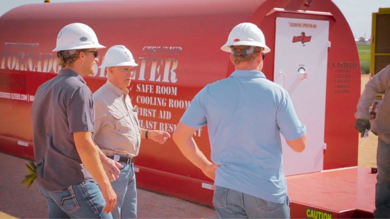 orkers standing near a multi-functional unit tailored as a custom storm shelter.