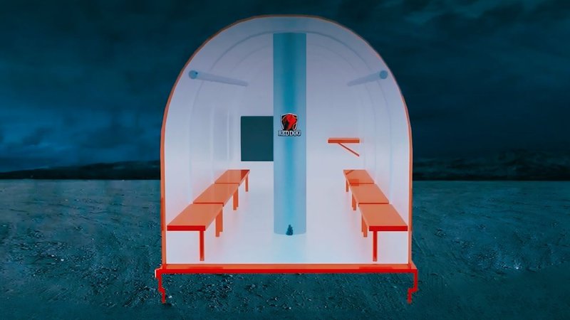 Red Dog commercial storm shelter structure with red benches inside, set against a dark, cloudy sky and desolate landscape.