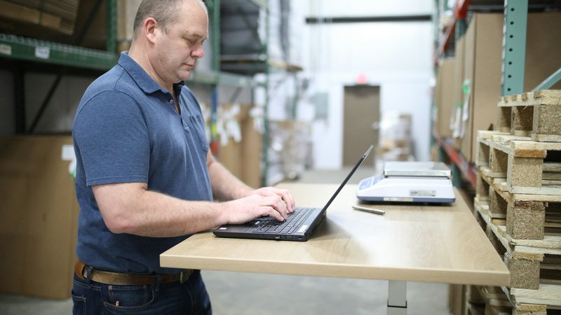 management checking on inventory on his laptop