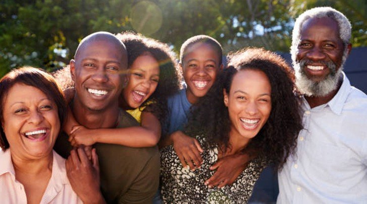 A family smiling outdoors.