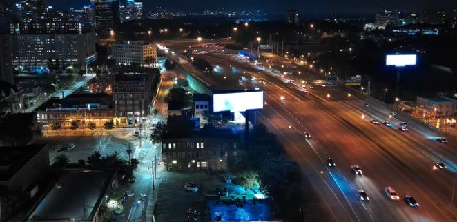 Nighttime highway billboards and city traffic 