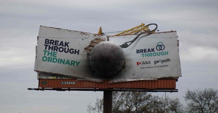 A 3D-style billboard installation with breakthrough creative design, showing OOH for lead generation