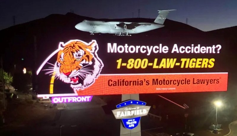 A Motorcycle Lawyer billboard with a picture of a tiger along the highway