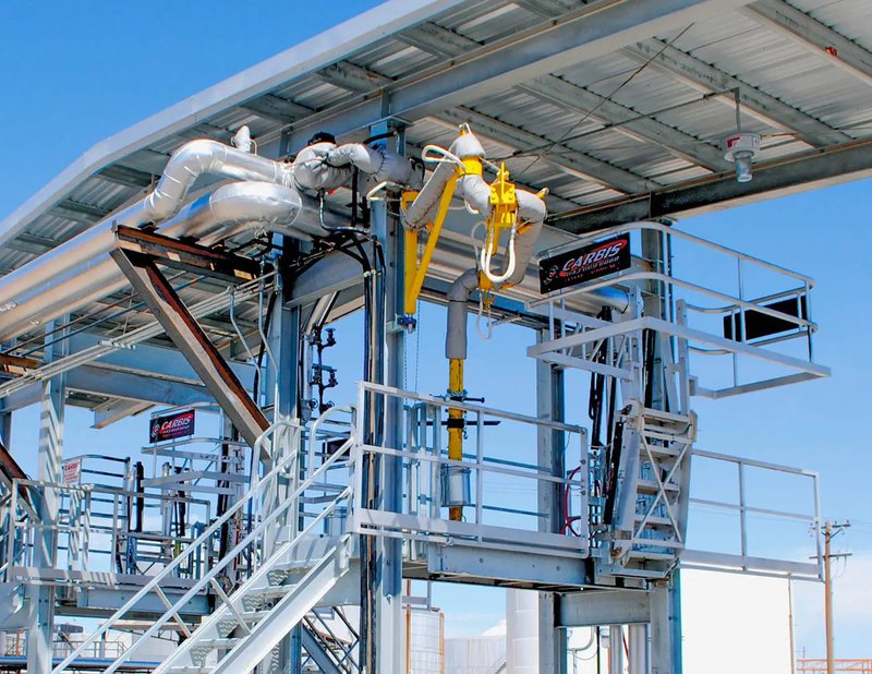 A top loading arm attached to the gangway of an industrial facility