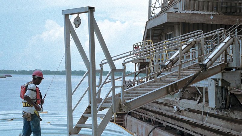 This photo features a worker about to cross a marine gangway