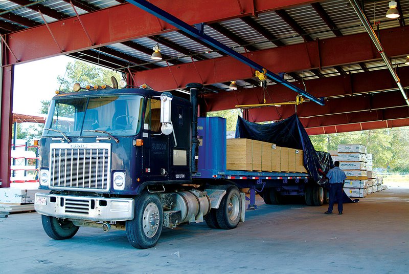 A flatbed with cargo being tarped