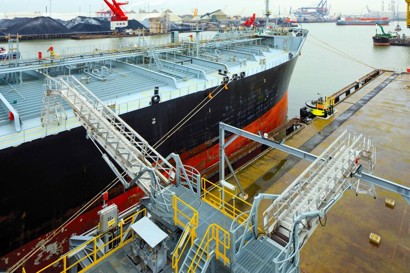 This photo features a ship with a gangway connecting it to the dock