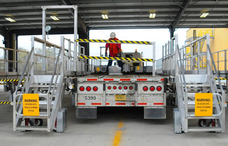 This photo features a crew member on the truck tarping platform